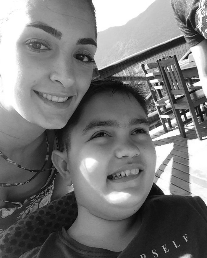 Esthevão Abner sorrindo ao ar livre, ao lado de uma jovem